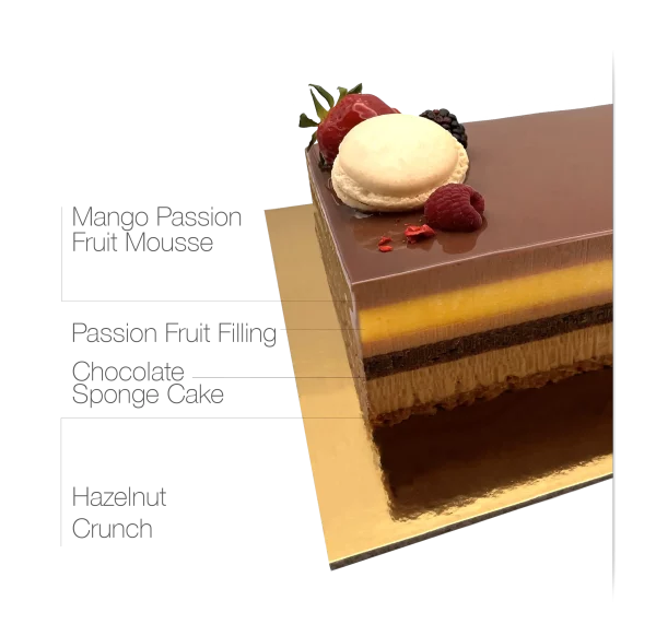 A luxurious Milk Chocolate Passion Mousse Cake adorned with chocolate, macarons, and fresh fruits.