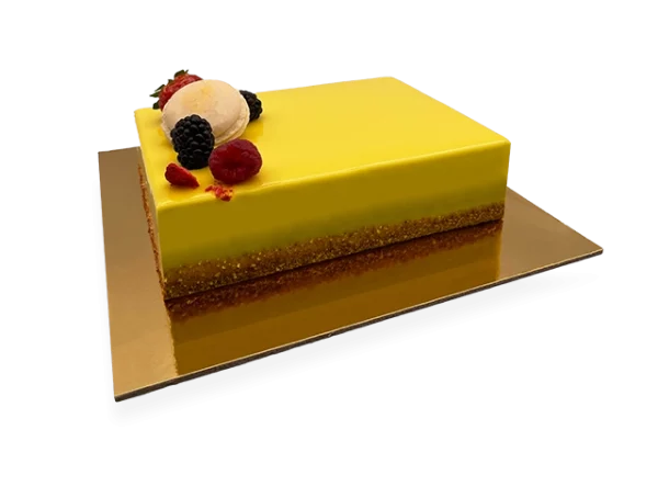 A slice of French Exotic cake, featuring layers of light sponge cake, tropical fruit filling, and a delicate whipped cream topping.