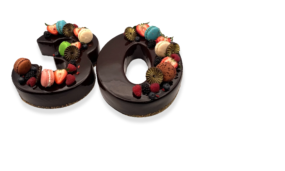 A pair of French chocolate number cakes, beautifully decorated with chocolate ganache, fresh berries, and edible flowers.