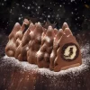 A luscious Buche De Noel Hazelnut Yule Log by PIERRE AND MICHEL, featuring a winter forest design. Layers of dark chocolate mousse, hazelnut filling, and a chocolate hazelnut crunchy biscuit create a festive delight.