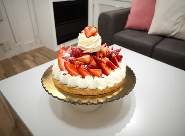 A luscious strawberry tart adorned with fresh fruit from Pierre and Michel's French Bakery, perfect for birthdays.