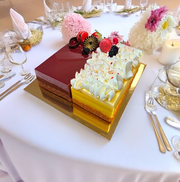 A delectable Duo Cake featuring two layers with different flavors, beautifully decorated with swirls of frosting and fresh fruit toppings.
